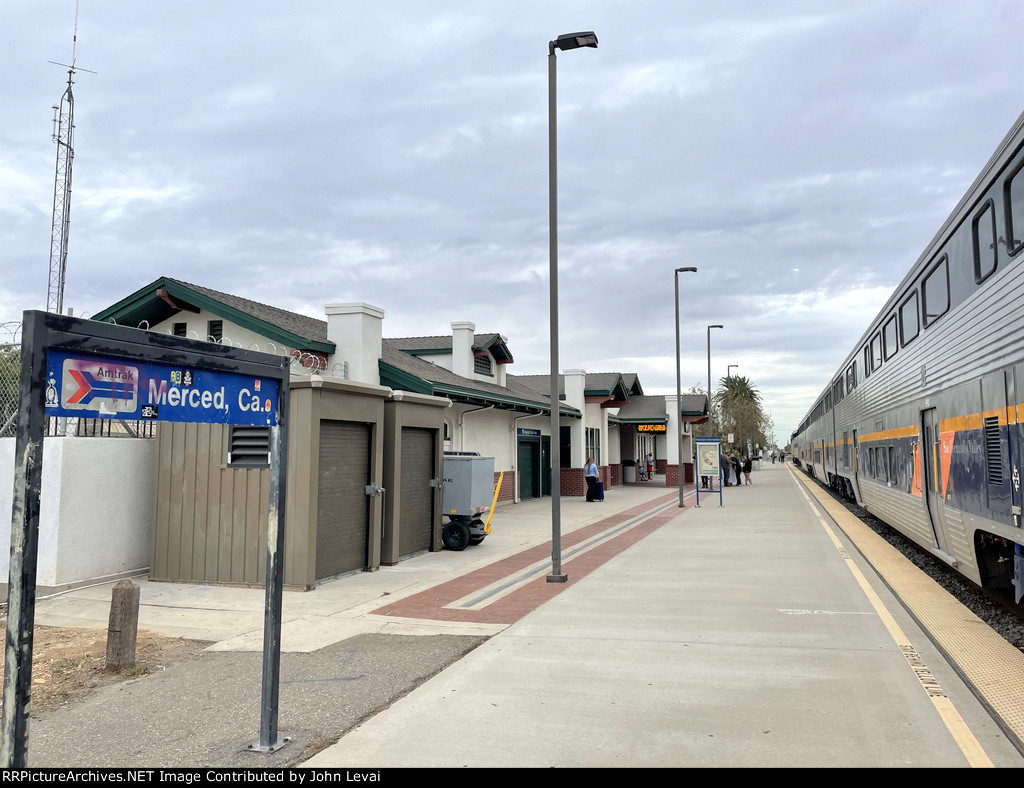 A broken arrow Amtrak logo station sign at Merced depot 